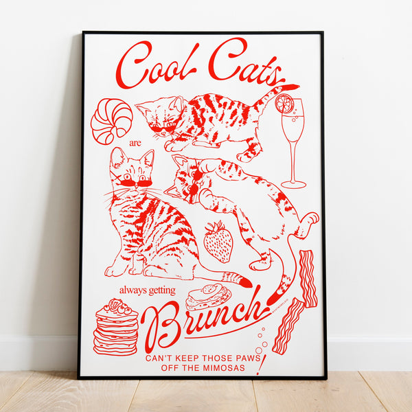 a poster leaning against a wall featuring three kittens alongside breakfast and brunch foods with the phrase cool cats are always getting brunch and the phrase can't keep those paws off the mimosas below