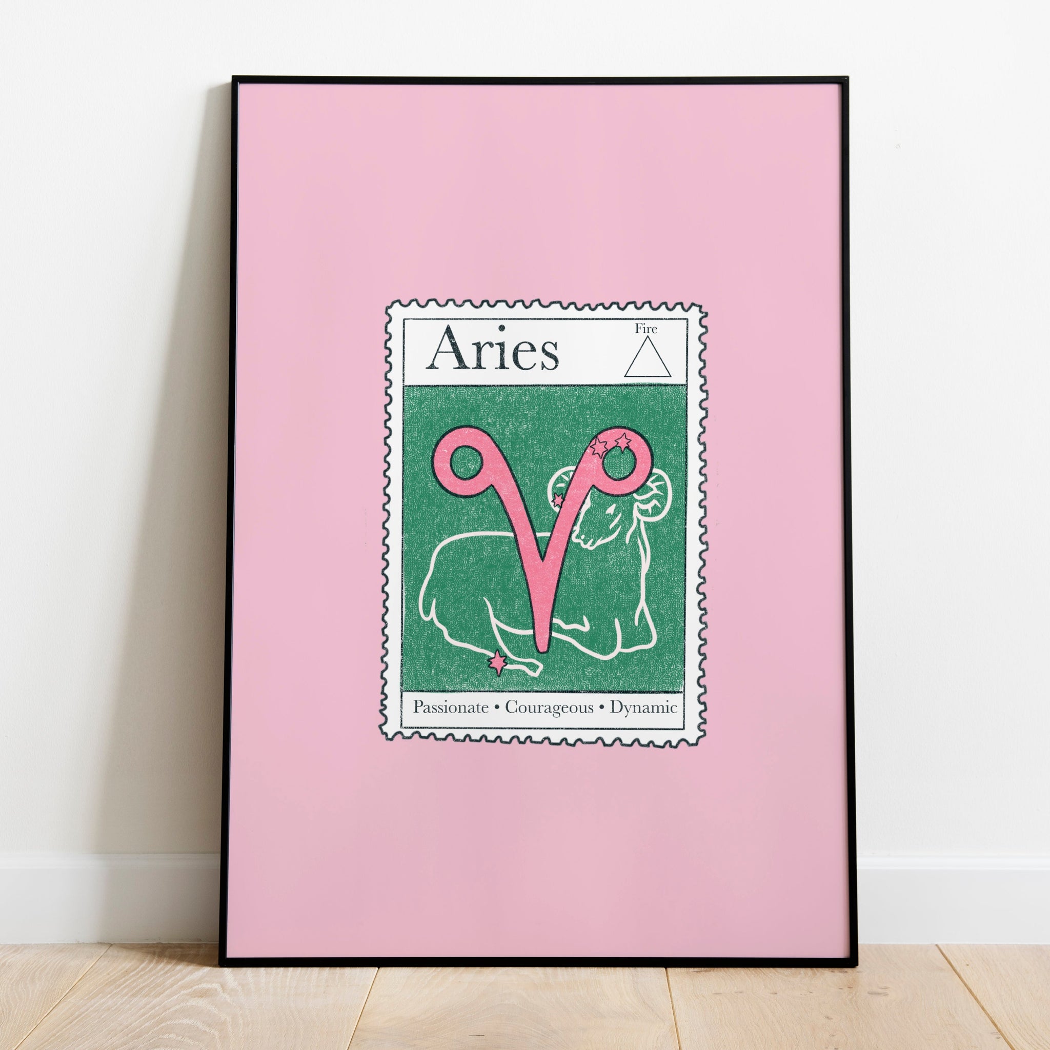Image of a framed art print leaning against the wall. The art print itself is a postage stamp representing the star sign of Aries. The print is bright and colourful in shades of green, pinks and cream.