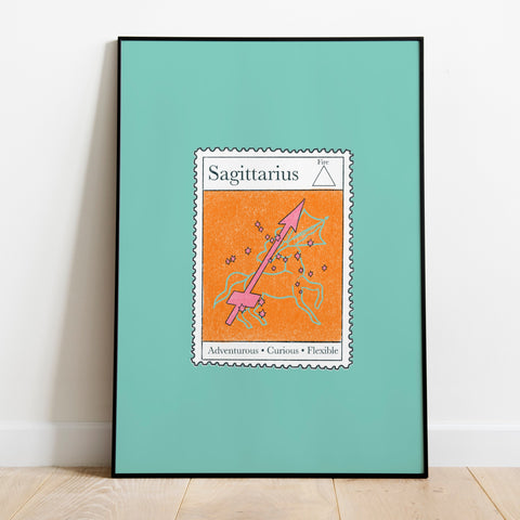 Image of a framed art print leaning against the wall. The art print itself is a postage stamp representing the star sign of sagittarius. The print is bright and colourful in shades of orange, teal and pink.