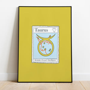 Image of a framed art print leaning against the wall. The art print itself is a postage stamp representing the star sign of taurus. The print is bright and colourful in shades of green, blue and red.