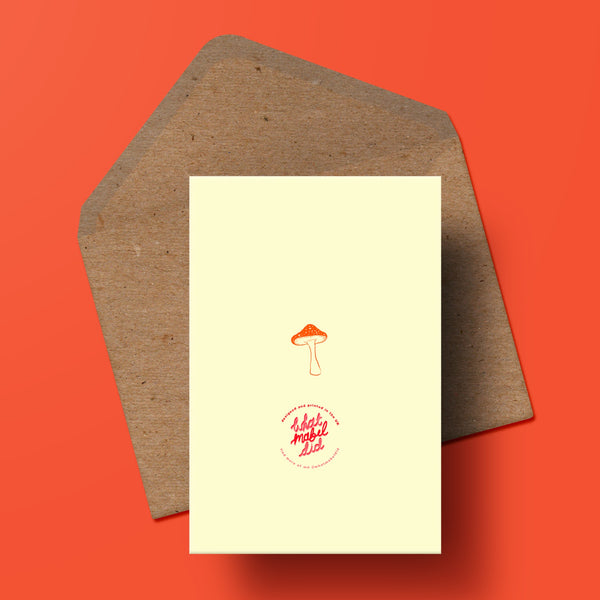 image of the behind of a greetings card featuring a toadstool and the whatmabeldid logo. beneath the card is a recycled kraft envelope.