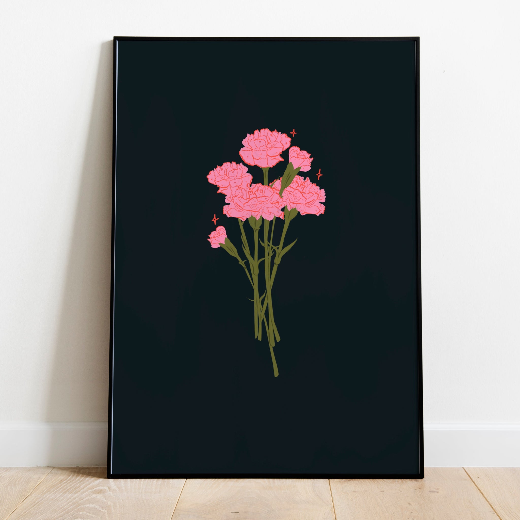 a framed art print of a bunch of pink carnations on a very dark blue background. The frame is leaning up against a white wall and wooden flooring