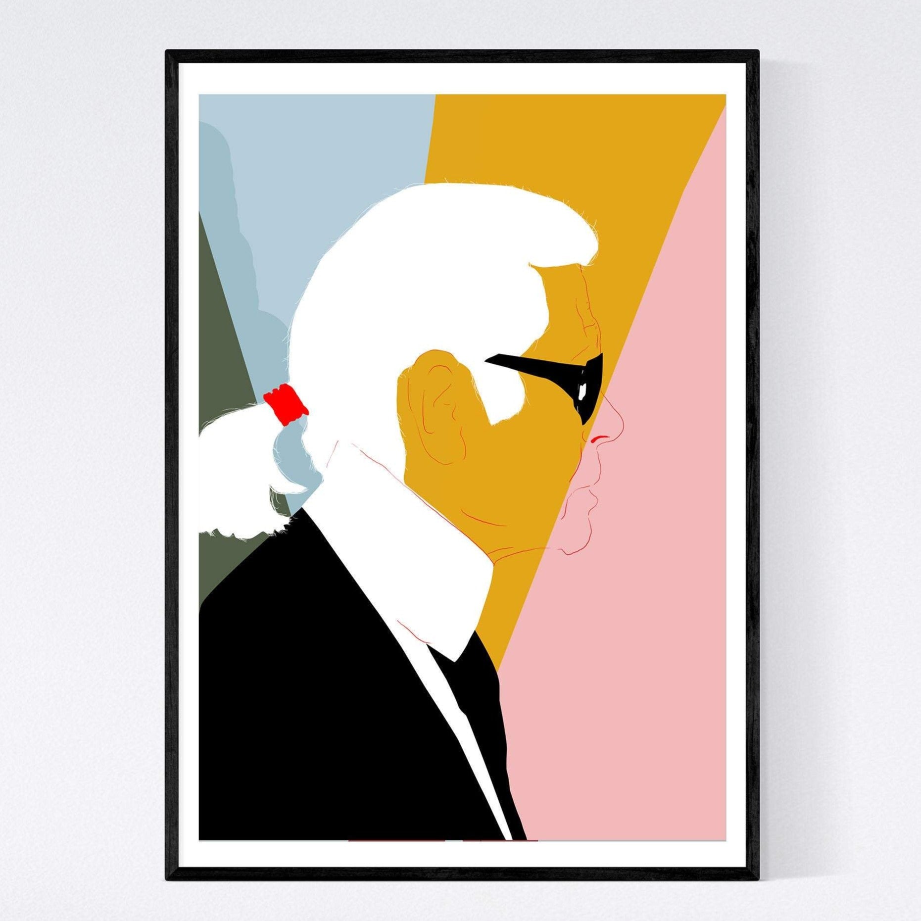 illustration print of karl lagerfeld in profile with swatches of blue, pink, yellow and green behind him. the print is in a minimal frame on a white wall.