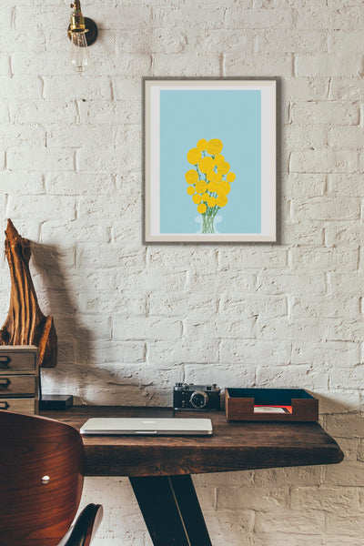 illustration of yellow billy buttons, sometimes known as craspedia globosa in a vase on a light blue background. the print is framed and in a minimal loft style space