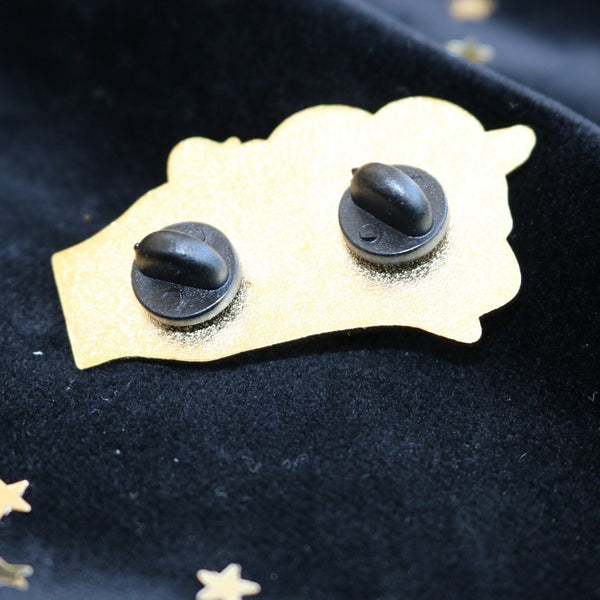 a look at the underside of the snake enamel pin which shows there are two point of attachment. the underside of the pin is gold.