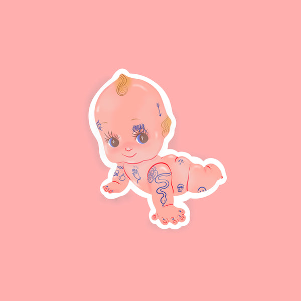 image of a sticker featuring an illustration of a kewpie doll with a collection of tattoos.