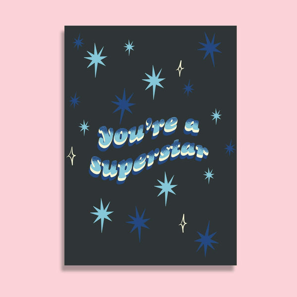 postcard with the words you're a superstar in wavy gradient blue text. the background is a deep navy with a pattern of blue stars.