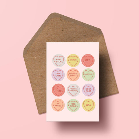 image of a pink greetings card with 12 love heart sweets with different messages on them.
